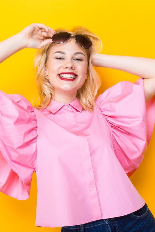 happy-blonde-woman-pink-blouse-with-sunglasses-min